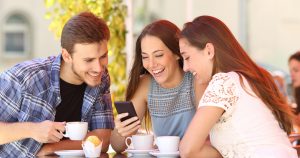 Three young people watching video on mobile device