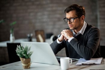 Man studying laptop screen
